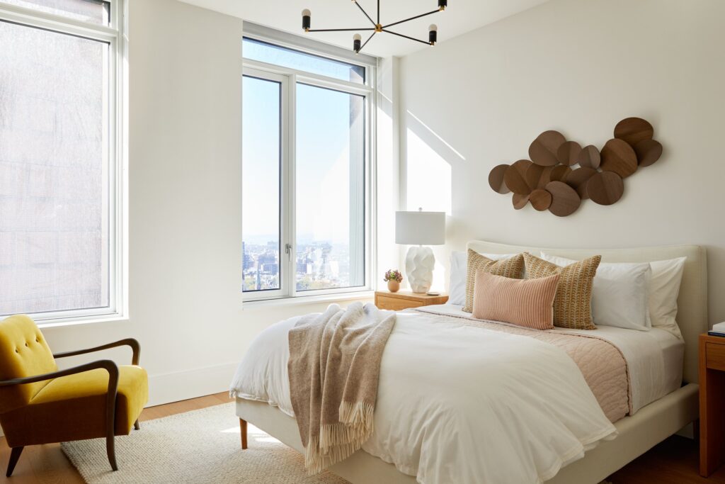 Airy style bedroom with neutral tones and abstract art on wall.