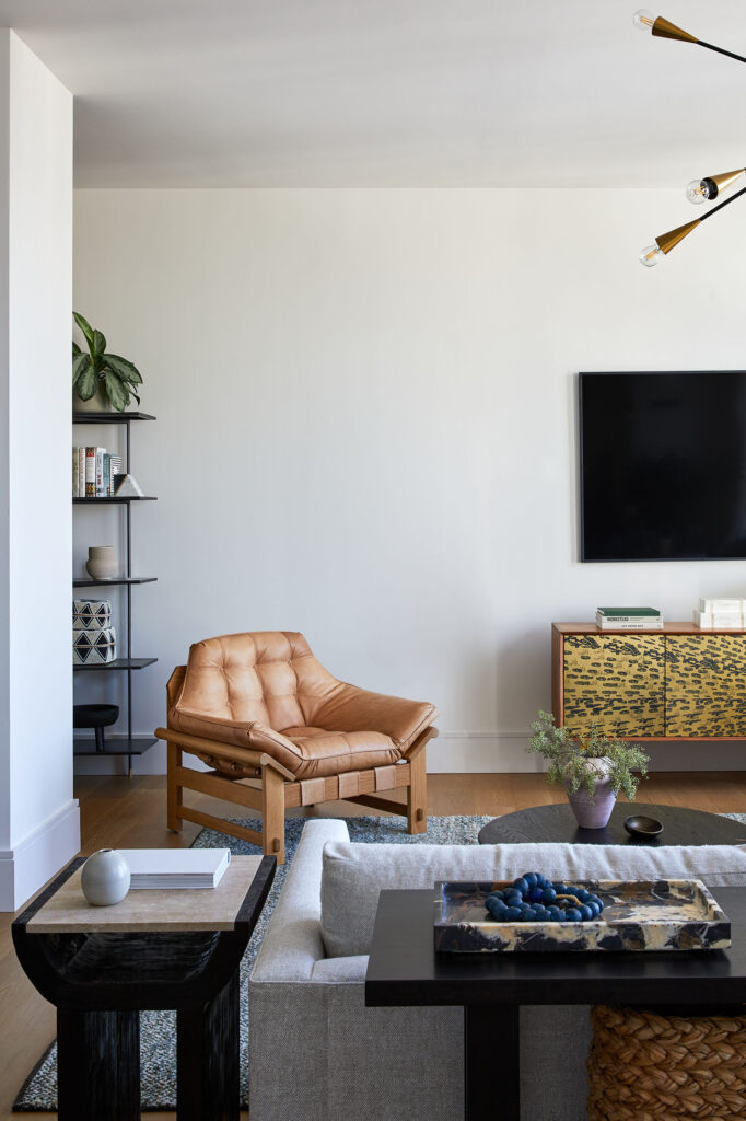 Living room with leather accents and an earth-toned rug lend warmth.