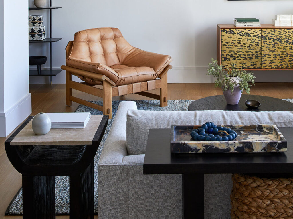 Modern living room with camel sofa and colorful design elements.