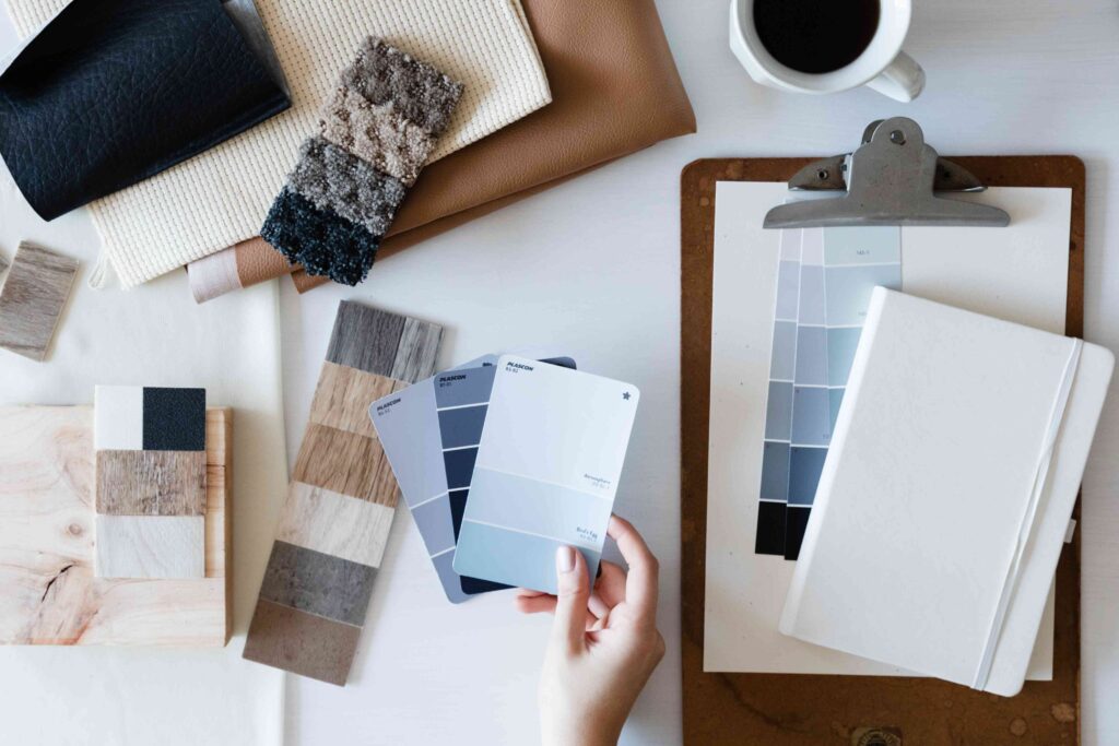 Interior designer desk with textured fabrics, paint tones and clip board.