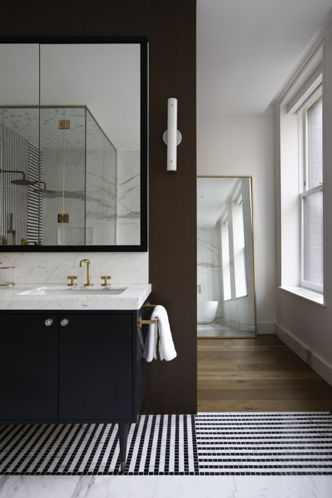 Luxury modern bathroom design with marble countertops and gold faucet.