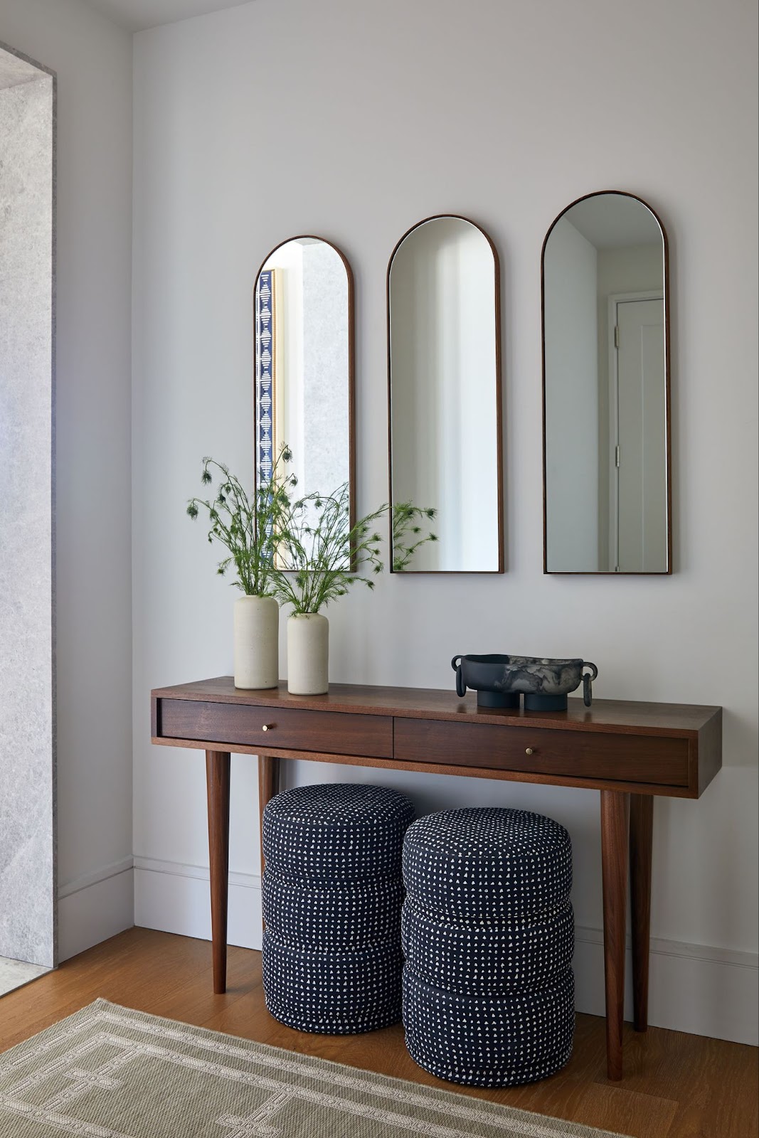 Functional entryway with side by side arched mirrors.