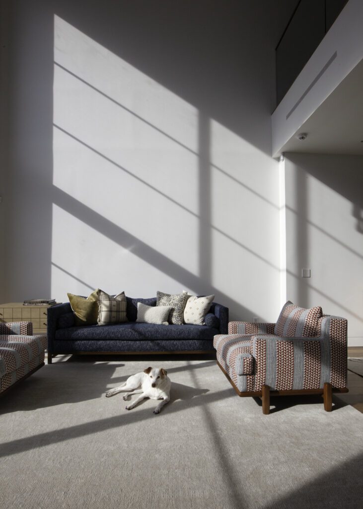 Modern living room with patterned chairs and a blue sofa, designed for family living with elegance and practicality.