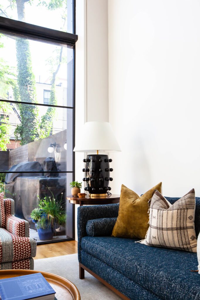 Blue sofa with accent pillows in a modern family-friendly living room designed by Atelier Roux.